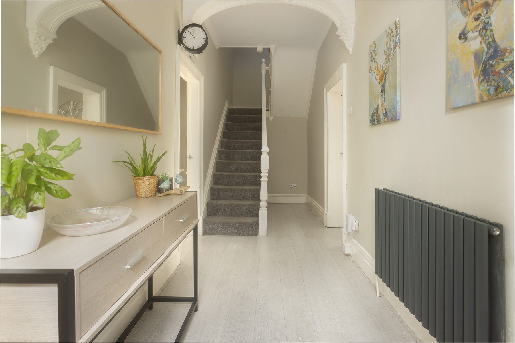 The hallway at Willow Bank, with a long console table, mirror and staircase.