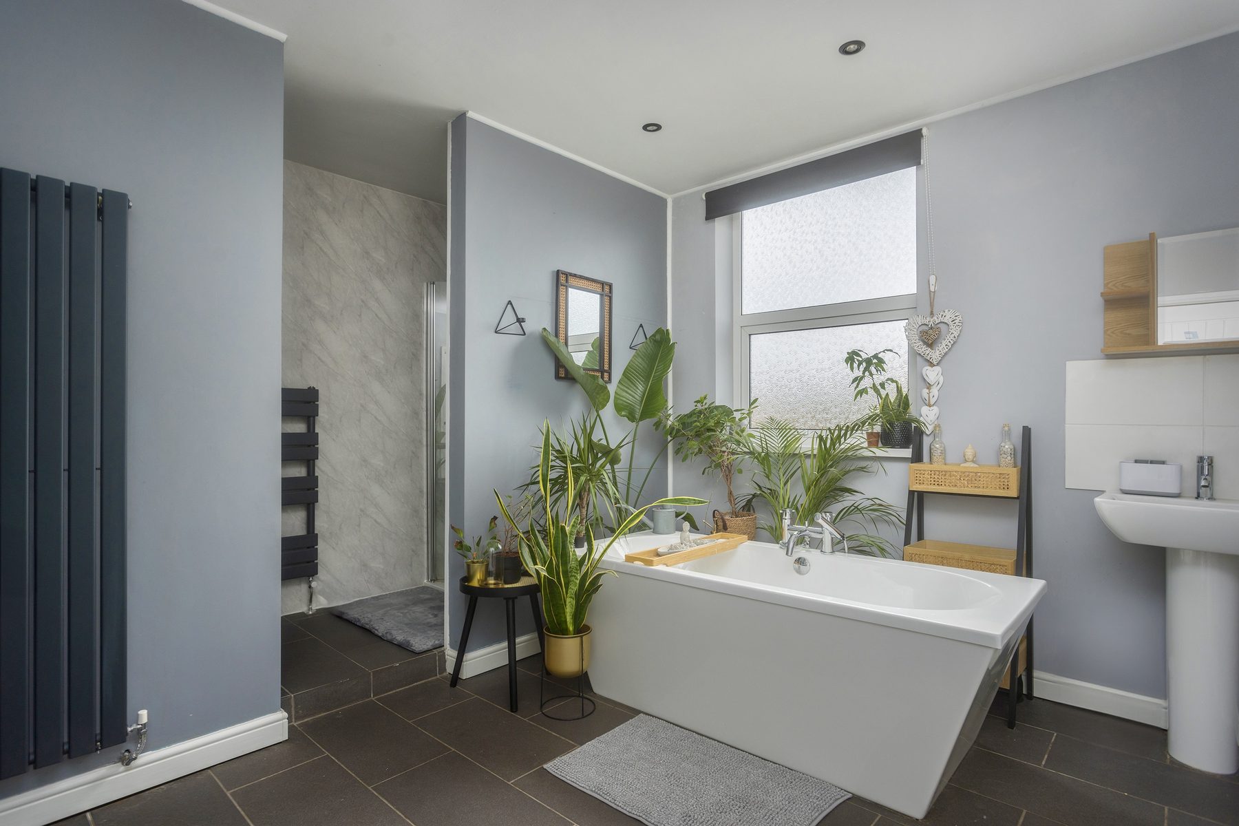 The main bathroom, with a freestanding bath and houseplants.